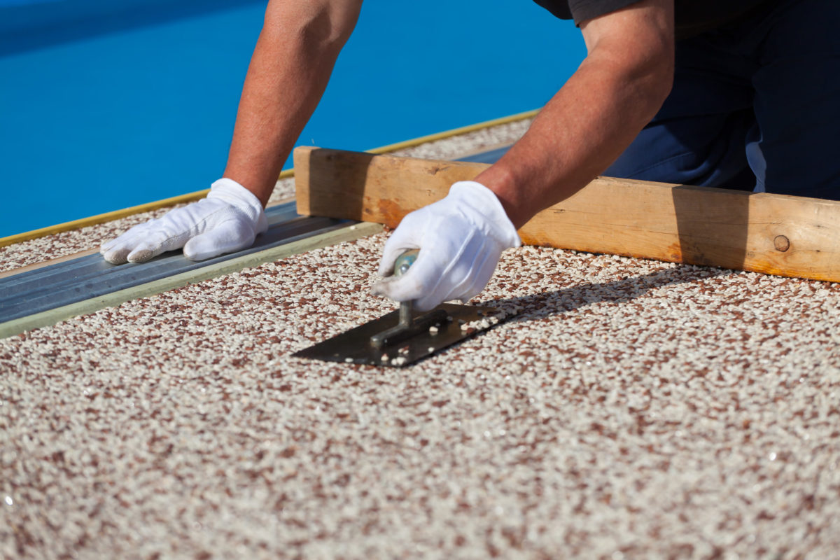 The worker places a stone carpet with resin.
(Shallow DOF).